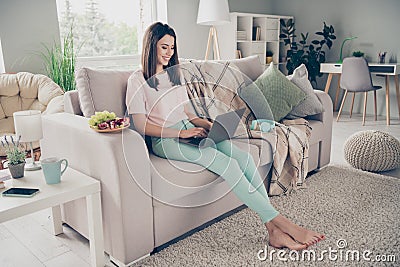 Photo portrait of young woman sitting on couch with laptop chatting smiling indoors Stock Photo