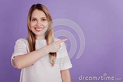 Photo of positive advertiser lady indicate empty space wear casual clothes on violet background Stock Photo