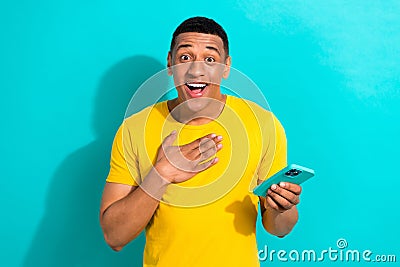 Photo of positive excited guy wear yellow t-shirt communicating instagram twitter telegram facebook isolated teal color Stock Photo