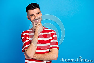 Photo of positive minded young man look empty space dream hold hand chin plan isolated on blue color background Stock Photo