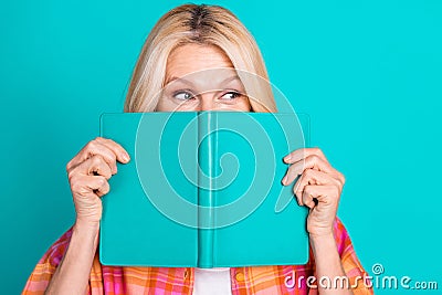 Photo of positive person with blond hair dressed checkered shirt peek from book look empty space isolated on teal color Stock Photo