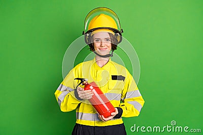 Photo of positive sweet young firewoman dressed yellow uniform helmet extinguishing smiling isolated green color Stock Photo