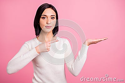 Photo of pretty business lady indicating finger on open palm presenting new product wear white pullover isolated pink Stock Photo