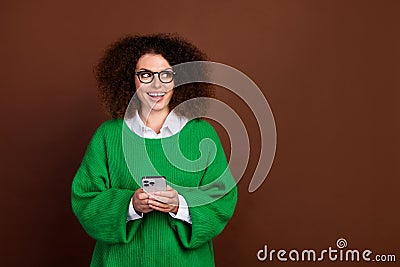 Photo of pretty excited person hold smart phone look empty space instagram facebook telegram isolated on brown color Stock Photo