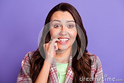 Photo of pretty guilty young woman bite teeth nails wear plaid shirt isolated on purple color background Stock Photo