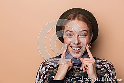 Photo of pretty joyful woman smiling and pointing at her cheeks Stock Photo