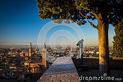 Public monocular on the top of a mountain with spectacular aerial views of the old city of Verona in Italy. Stock Photo