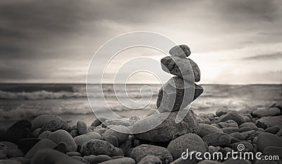 Photo of the pyramid of the stones on ocean background. Sepia style. Stock Photo