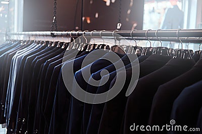 Photo of a rack with suit jackets in a menswear store. Stock Photo