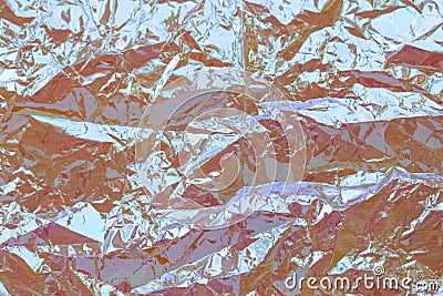 Photo of a real bright crumpled holographic background with texture in yellow toned. Stock Photo