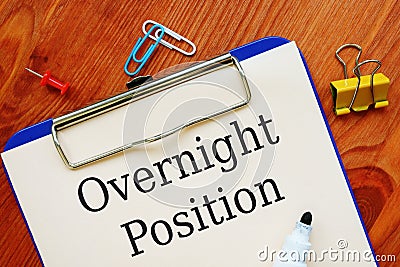 The photo says Overnight Position. Notepad, marker Stock Photo