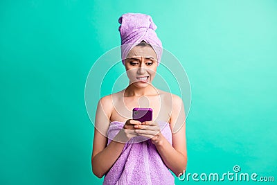 Photo of scared troubled lady bite lips morning shower hold telephone wear violet towels isolated teal color background Stock Photo