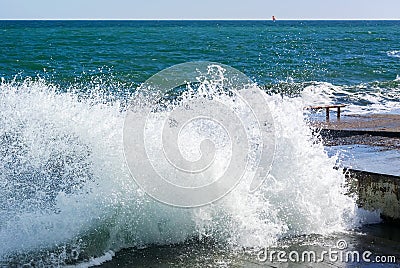 Photo of the sea wave breaking on the concrete mooring on a huge number of splashes Stock Photo