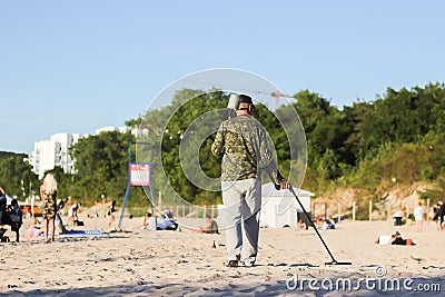 Searching for a precious metal on the beach Editorial Stock Photo