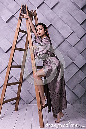 Charming model posing near ladder in the photo shooting process Stock Photo
