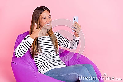 Photo of shiny dreamy lady wear striped sweater sitting beanbag showing thumb up tacking selfie modern gadget Stock Photo