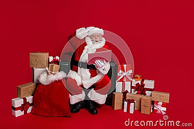 Photo of shoked amazed santa claus wear red headwear hat working modern device hand arm head isolated red color Stock Photo