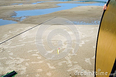 Photo shooting footage with fishing rod and bait Popper with reflector light and hand girl assistant on a sandy beach Stock Photo