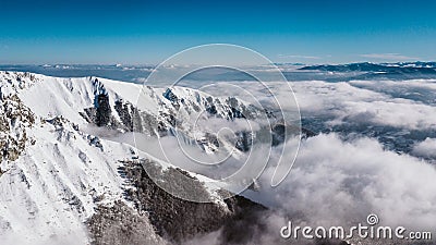 A mountain cliff covered with snow, taken with drone Stock Photo