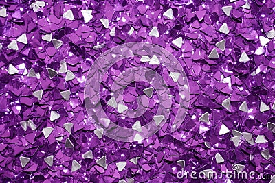 photo of silver glitter scattered on a vibrant purple surface Stock Photo