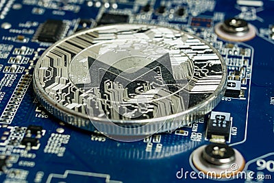 A single Monero coin on the blue computer motherboard Editorial Stock Photo