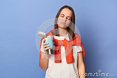 Photo of sleepy tired exhausted woman wearing casual style clothing, holding thermos with hot coffee, needs energy, being unhappy Stock Photo