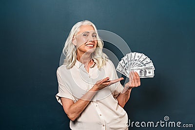 Smiling mature old woman showing money holding in hands. Stock Photo