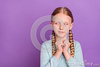 Photo of sneaky evil little girl hold fists look empty space planning wear blue shirt isolated violet color background Stock Photo