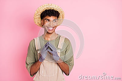 Photo of sneaky guy evil smile hold fingers look empty space wear straw hat beige overall isolated pink color background Stock Photo