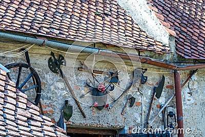 Photo of some medieval weapons and objects placed on a wall at the entrance of a small museum in the Rasnov Citadel - Rasnov, Stock Photo
