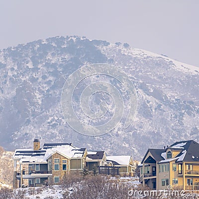 Photo Square frame Hilly residential terrain with charming homes and snowy natural beauty Stock Photo