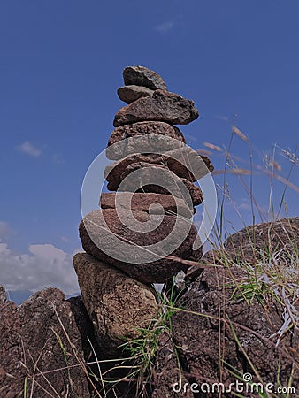 Photo of stack balanced stone at the peak of Maddo Hill, Barru, South Sulawesi, Indonesia with a blue skies background at noon. Stock Photo
