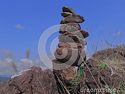 Photo of stack balanced stone at the peak of Maddo Hill, Barru, South Sulawesi, Indonesia with a blue skies background at noon. Stock Photo