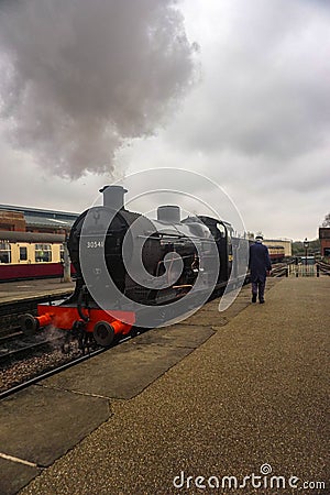 A photo of a steam train as it enters a platform Editorial Stock Photo