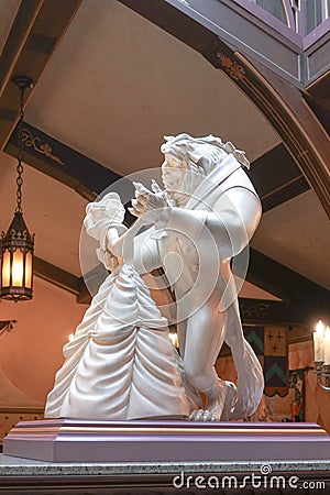 A photo of Stone Sculpture of Disney princess Belle and the Beast dancing together. Editorial Stock Photo