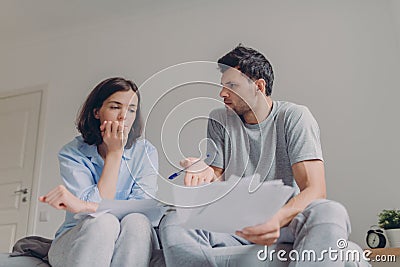Photo of stressful young family couple have many debts, prepare fincial report, think about future developing of their business, Stock Photo