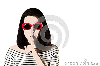 Photo in the style of pop art. Woman in red sunglasses shows gesture Shhh. Stock Photo