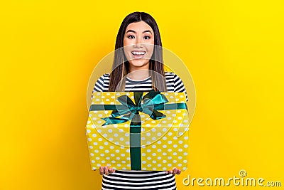 Photo of surprised funny chinese young woman hold gift new present from boyfriend anniversary holiday isolated on yellow Stock Photo