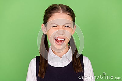 Photo of sweet funny school girl dressed formal clothes winking smiling green color background Stock Photo