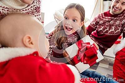 Photo of sweet impressed big family dressed new year pullovers smiling getting gifts indoors house home room Stock Photo