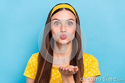 Photo of sweet shiny young woman wear dotted outfit sending arm kiss blue color background Stock Photo