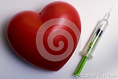 Syringe and a red blood stain in heart shape Stock Photo