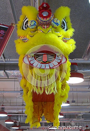 A bright yellow Chinese Lion Dance costume on display high up in the air Editorial Stock Photo