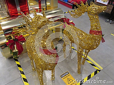 A Christmas decoration of a pair of golden reindeers pulling a golden sleigh Stock Photo