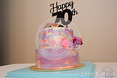 A colorful two tiered birthday cake for a seventy year old birthday celebration Stock Photo