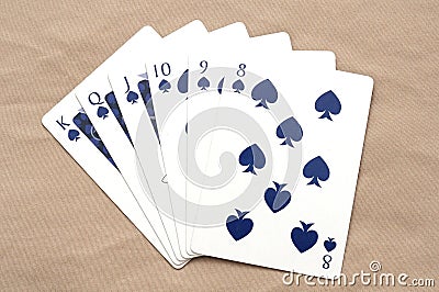 A set of poker cards showing a straight flush hand combination against a light brown beige backdrop Stock Photo