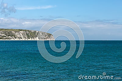 A photo taken on a spring day at Swanage beach looking towards the boats on the sea and the jurasic coast line Stock Photo