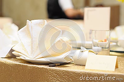 A table setup of beige and milky white tableware, napkins and guest name card at an asian restaurant Stock Photo