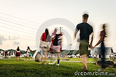 Blurred Motion of People Walking Across a Park to an Outdoor Concert Stock Photo