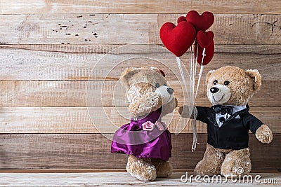 Teddy bear give heart-shaped balloon to his girl friend Stock Photo